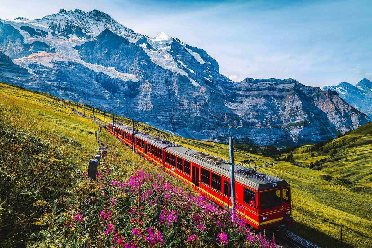 Cogwheel railway with electric red tourist train. Snowy Jungfrau 