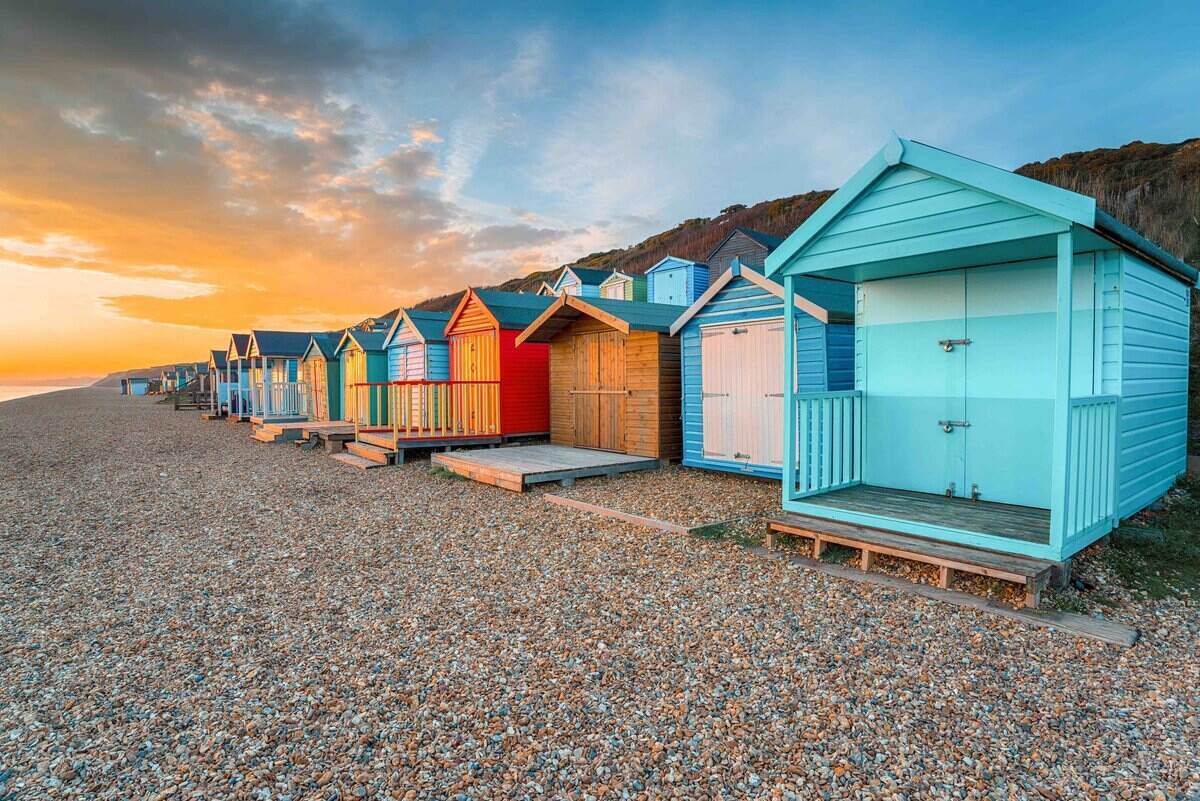 Stunning sunset over a row of brightly coloured beach huts at Milford on Sea on the Hampshire coast