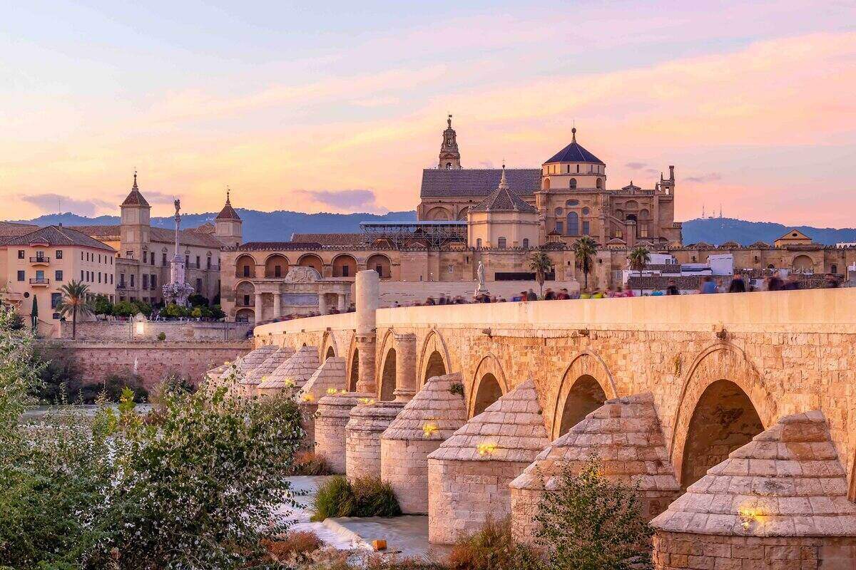 Mosque-Cathedral and the Roman Bridge at sunset in Cordoba, Andalusia, Spain